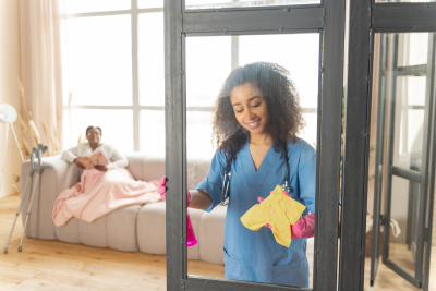 pleasant young nurse talking to patient and cleaning the glass door