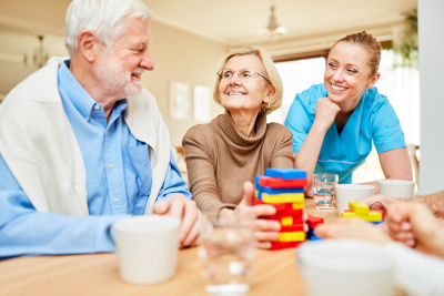 nurse taking care of senior citizens playing with building blocks