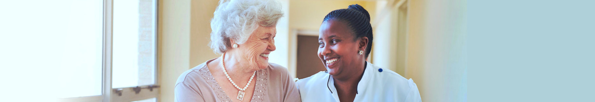 photo of a senior woman and caregiver walking together